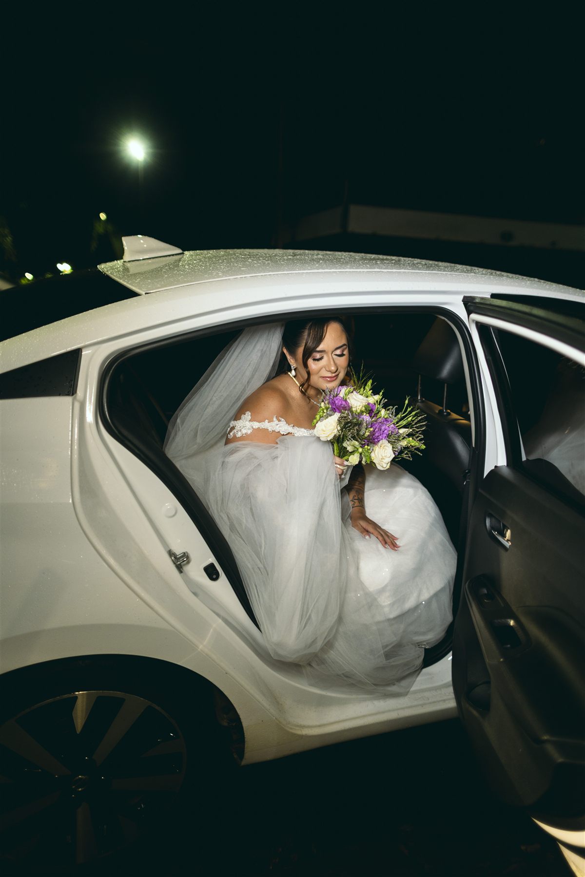 Noiva entrando no carro à noite